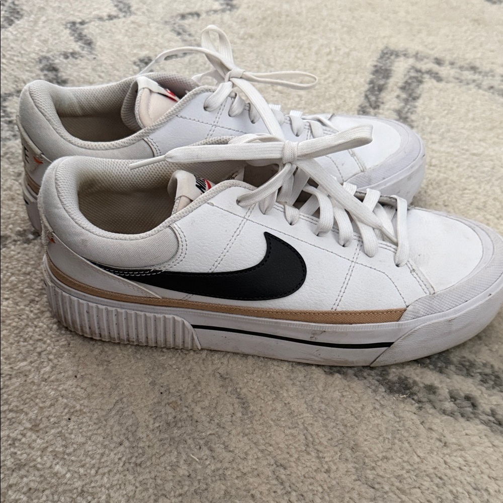 Nike White Low-Top Sneakers with Black Swoosh and Gold Stripe